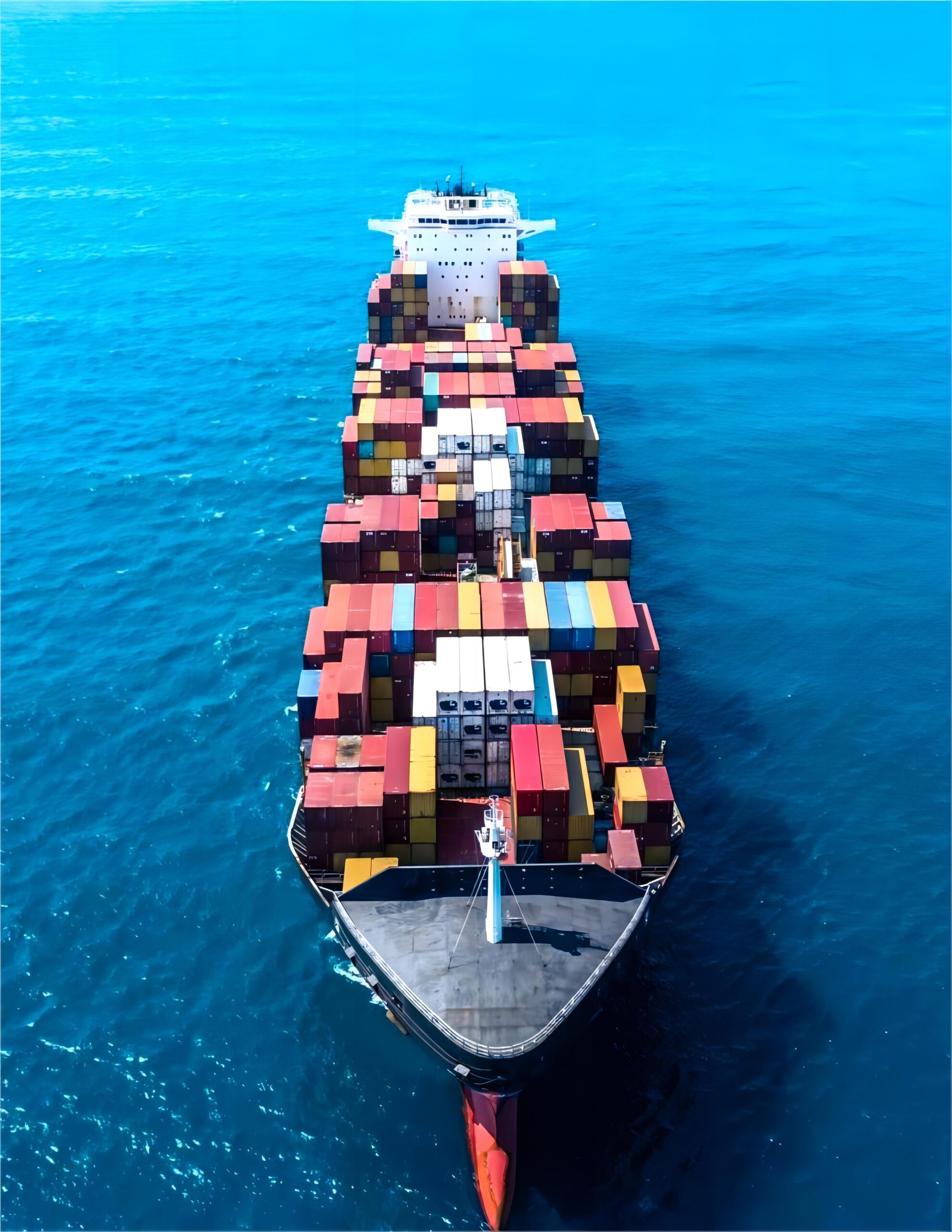 Cargo ship with containers sailing towards a sunset